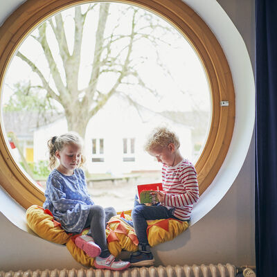 Kinder lesend in Fensterbank